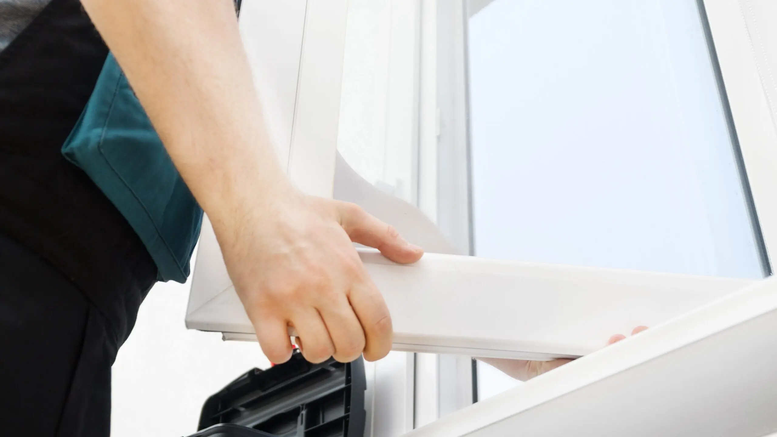 Close exterior view of a technician adjusting a window frame