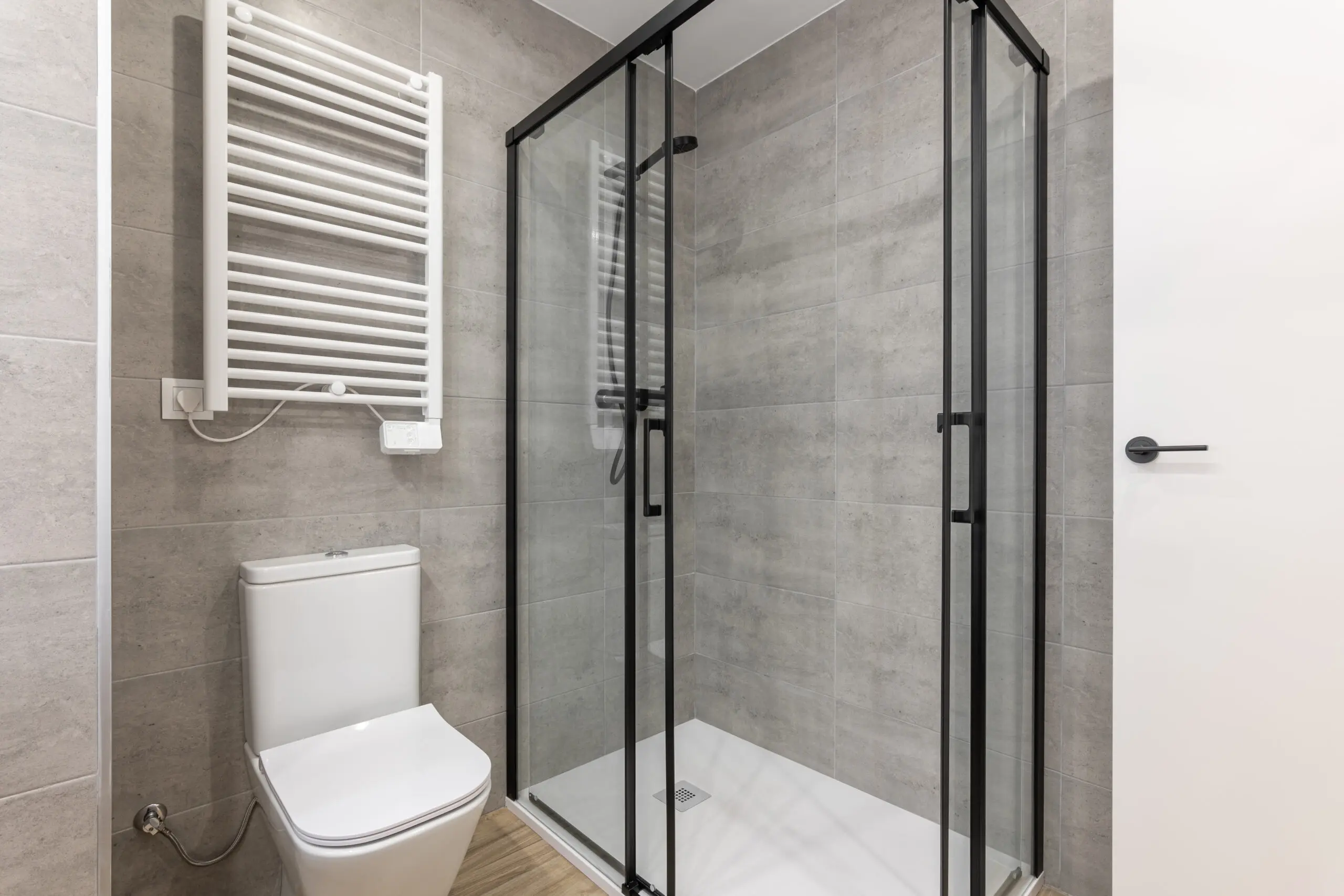 There is a shower enclosure with black perimeters.