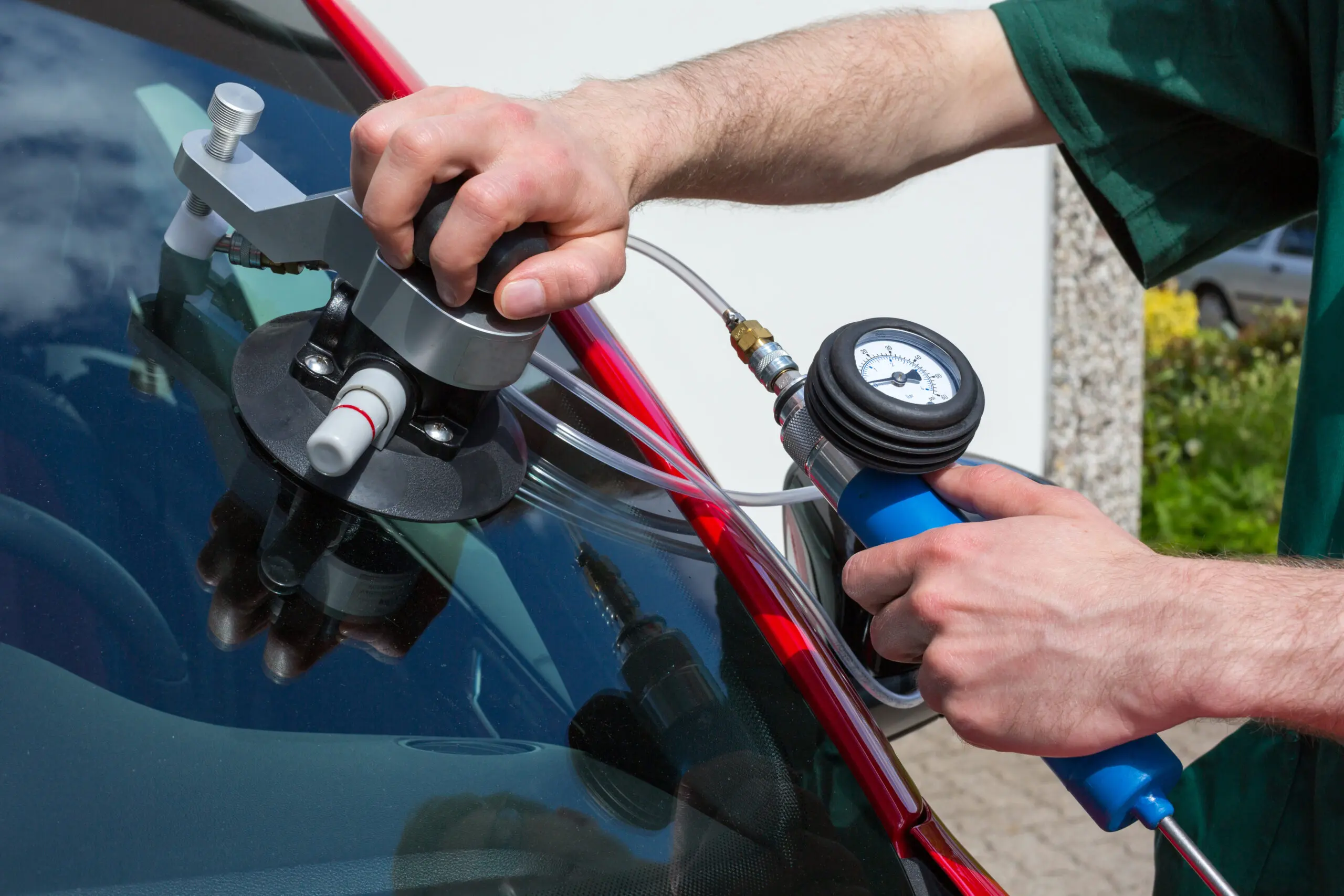 A windshield replacement is being applied to a car.