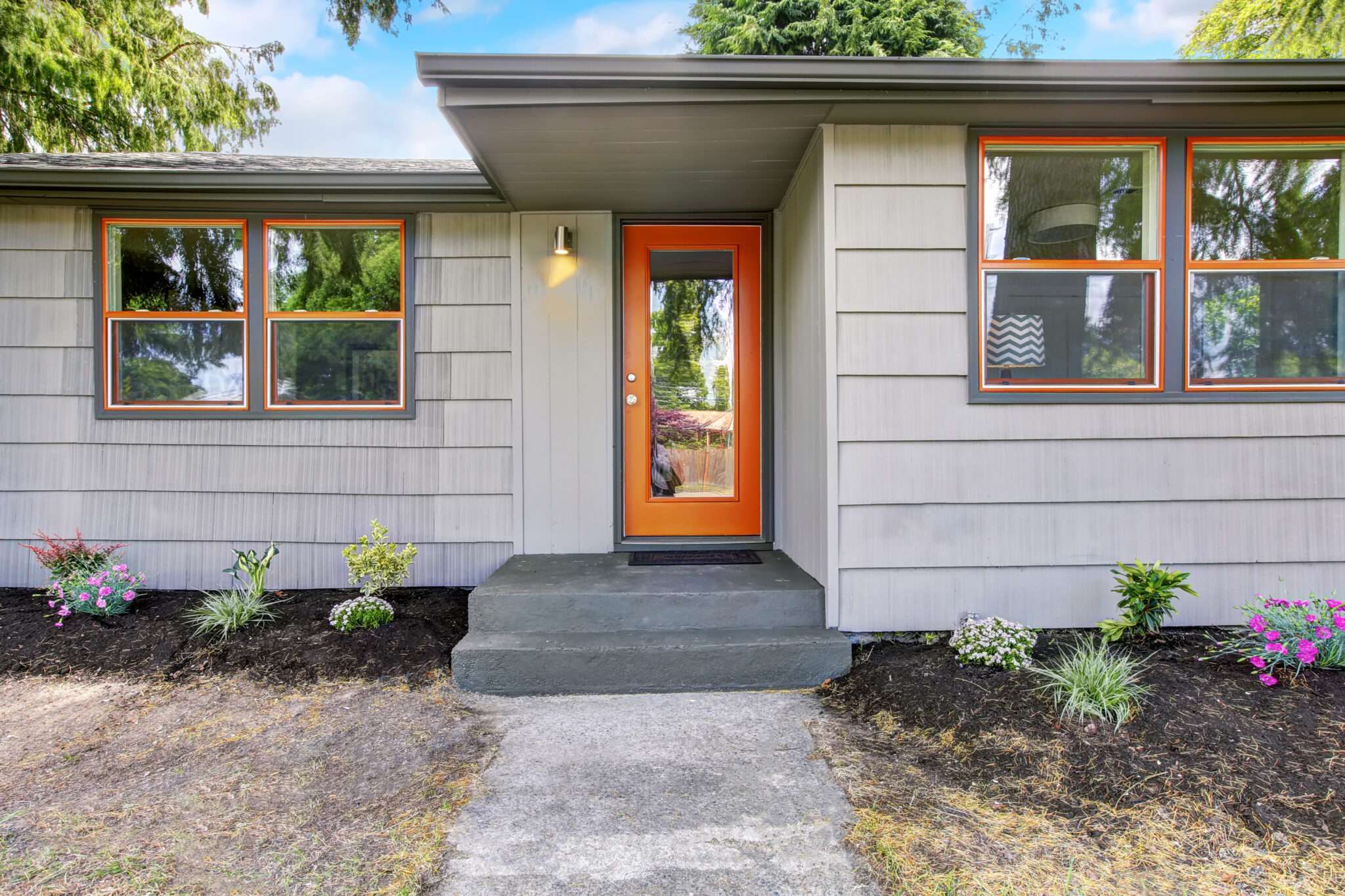 Orange framed windows and door on gray house