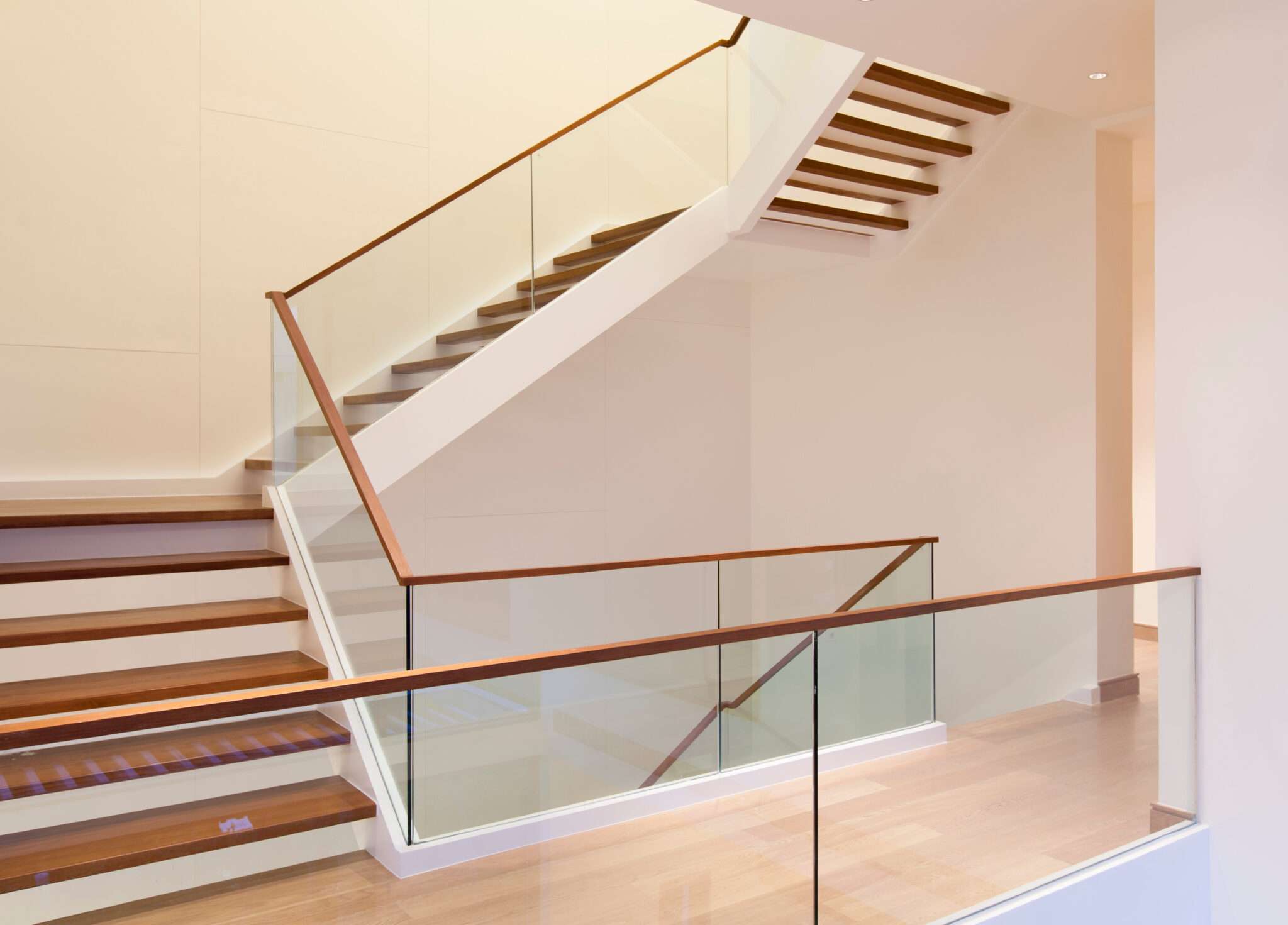 Glass railing with wood handrail on stairs