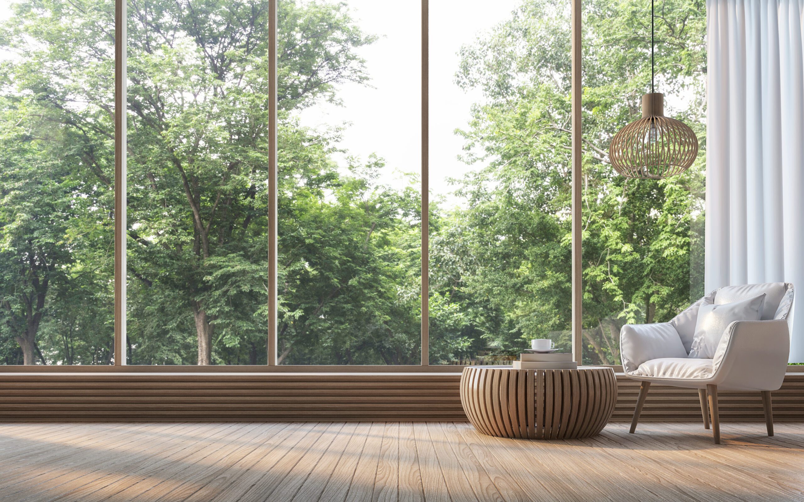 Large glass windows in sitting room with trees outside