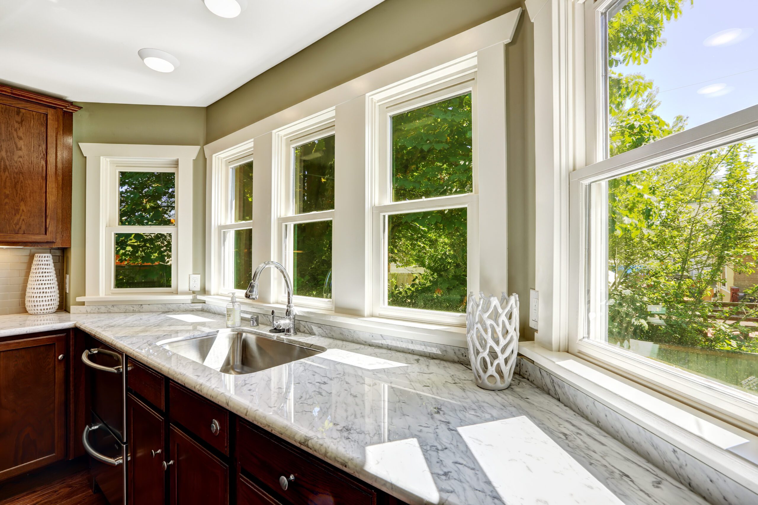 Kitchen counter with spacious windows overlooking lush green yard