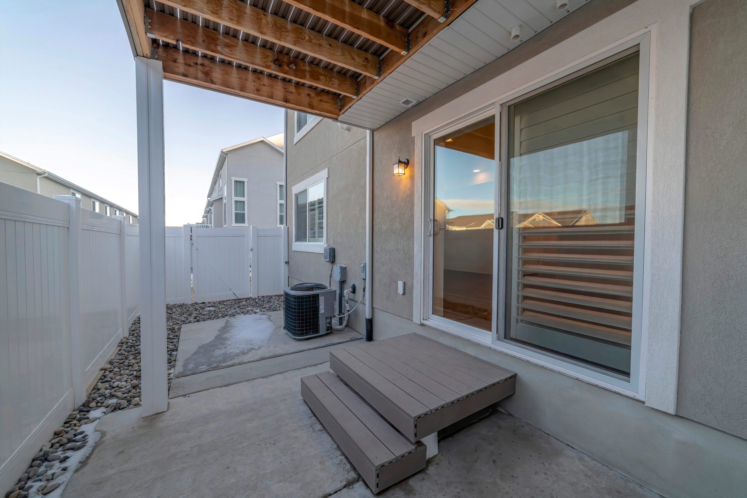 Sliding glass door to small patio fenced in yard