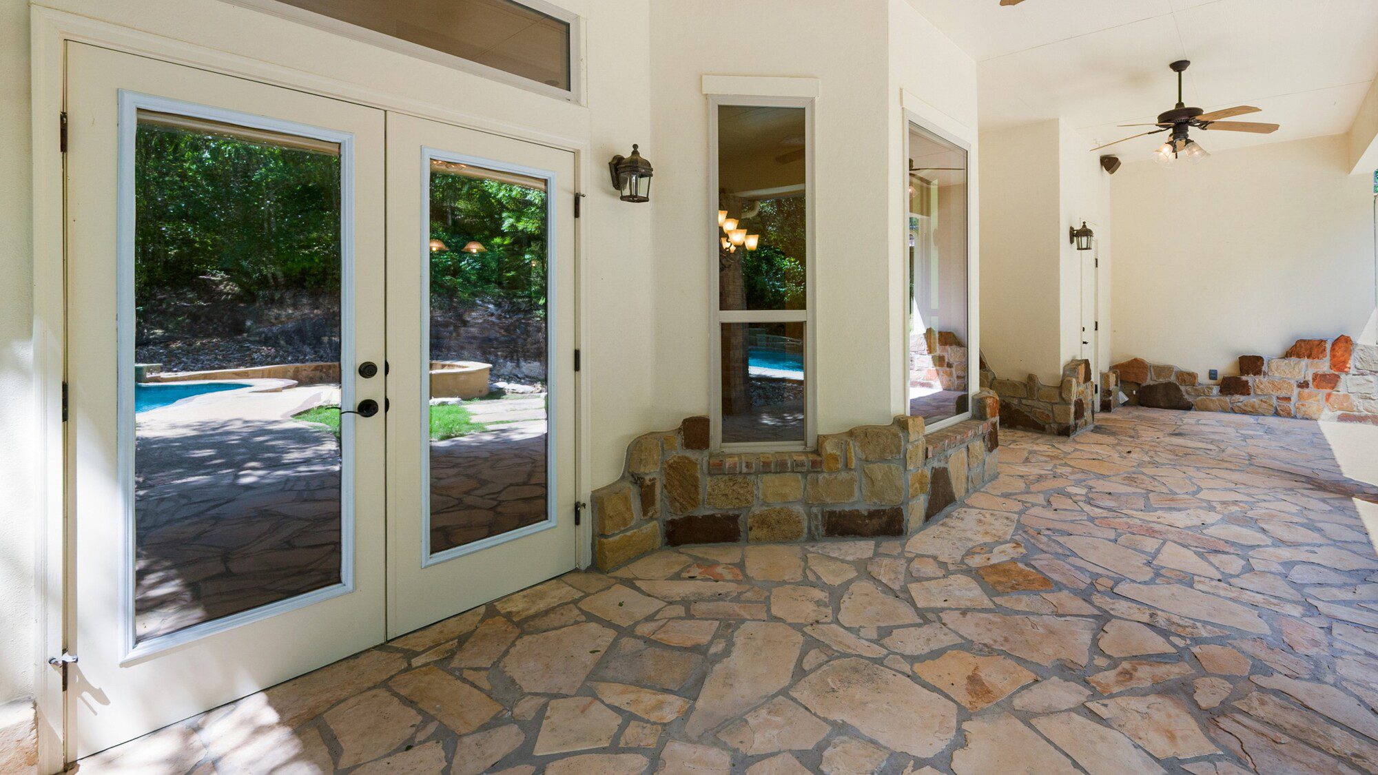 Outdoor view of newly installed glass patio doors on a stone patio