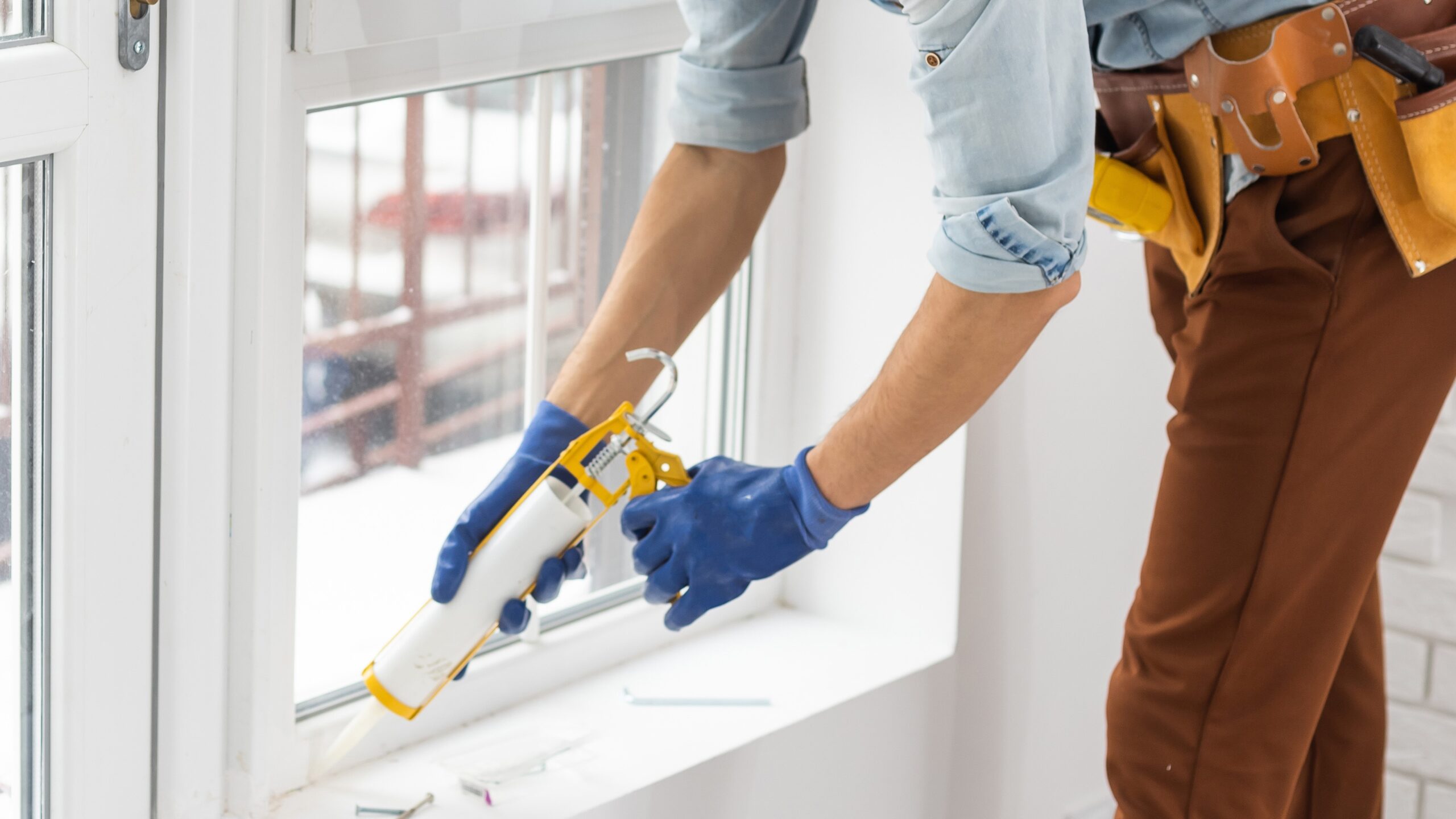 Close view of an installer sealing a newly replaced window