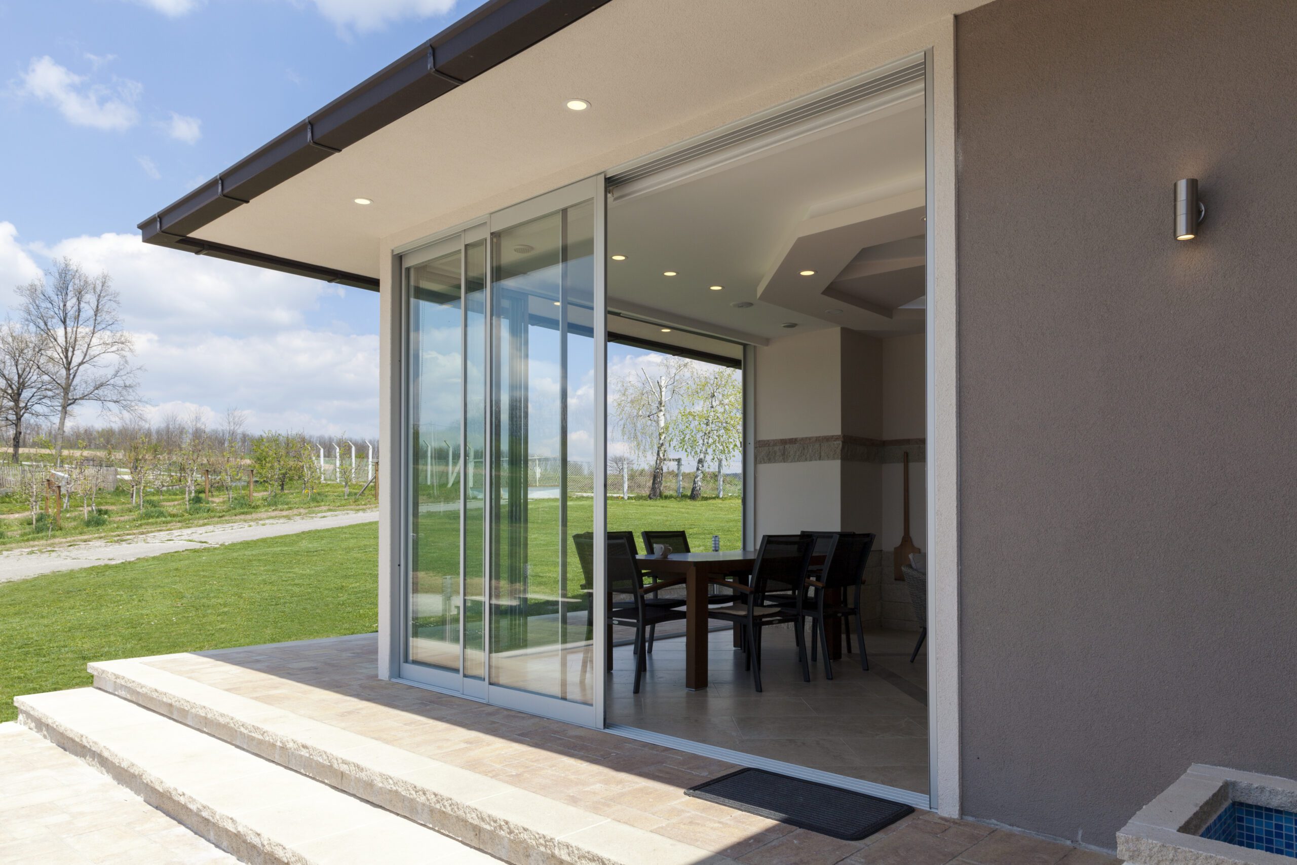 There is a sleek, sliding patio door on the home