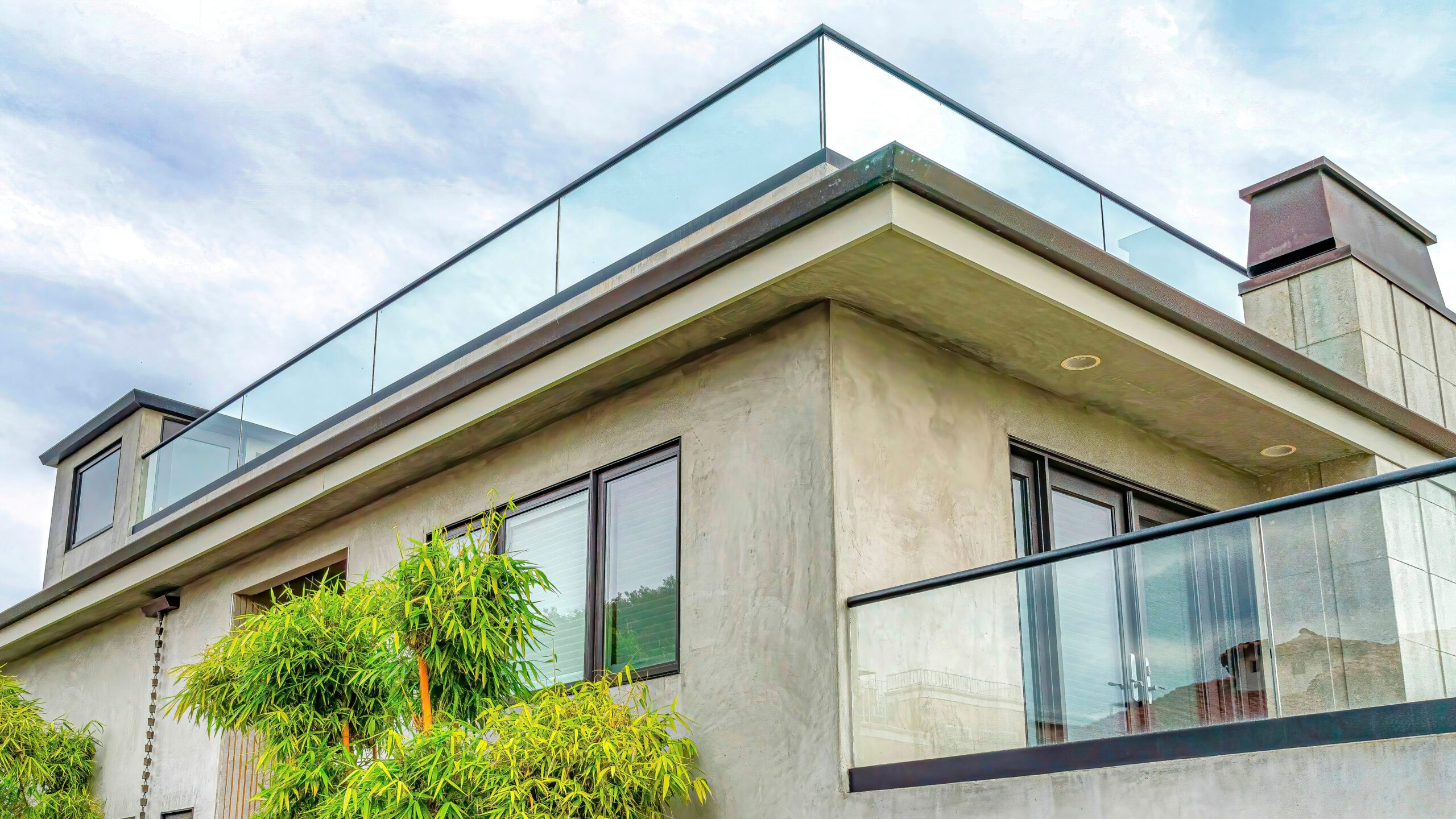 There is a view of a home with multiple glass railings