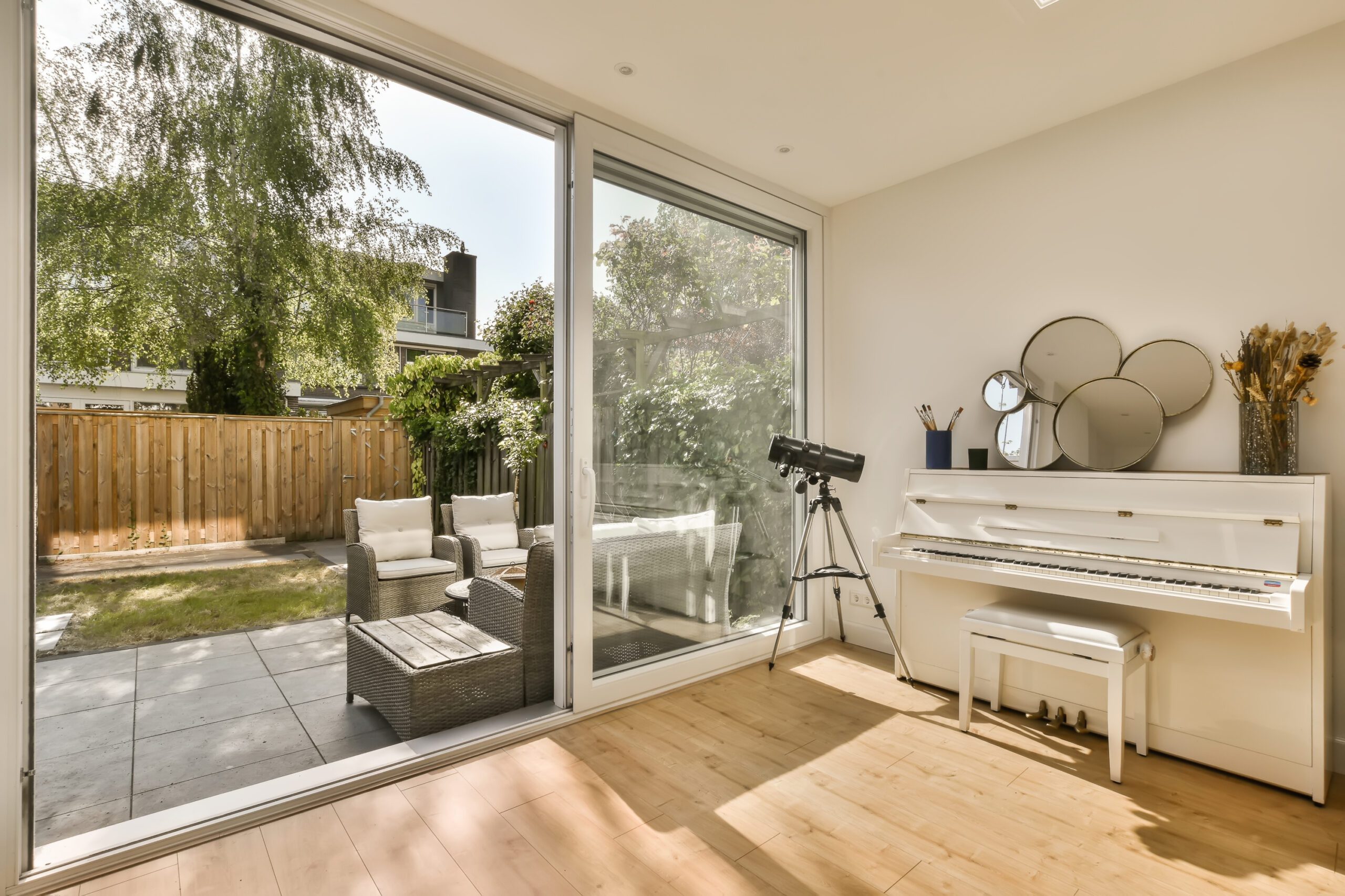 There is an open patio door with a view of the inside of the home and the backyard