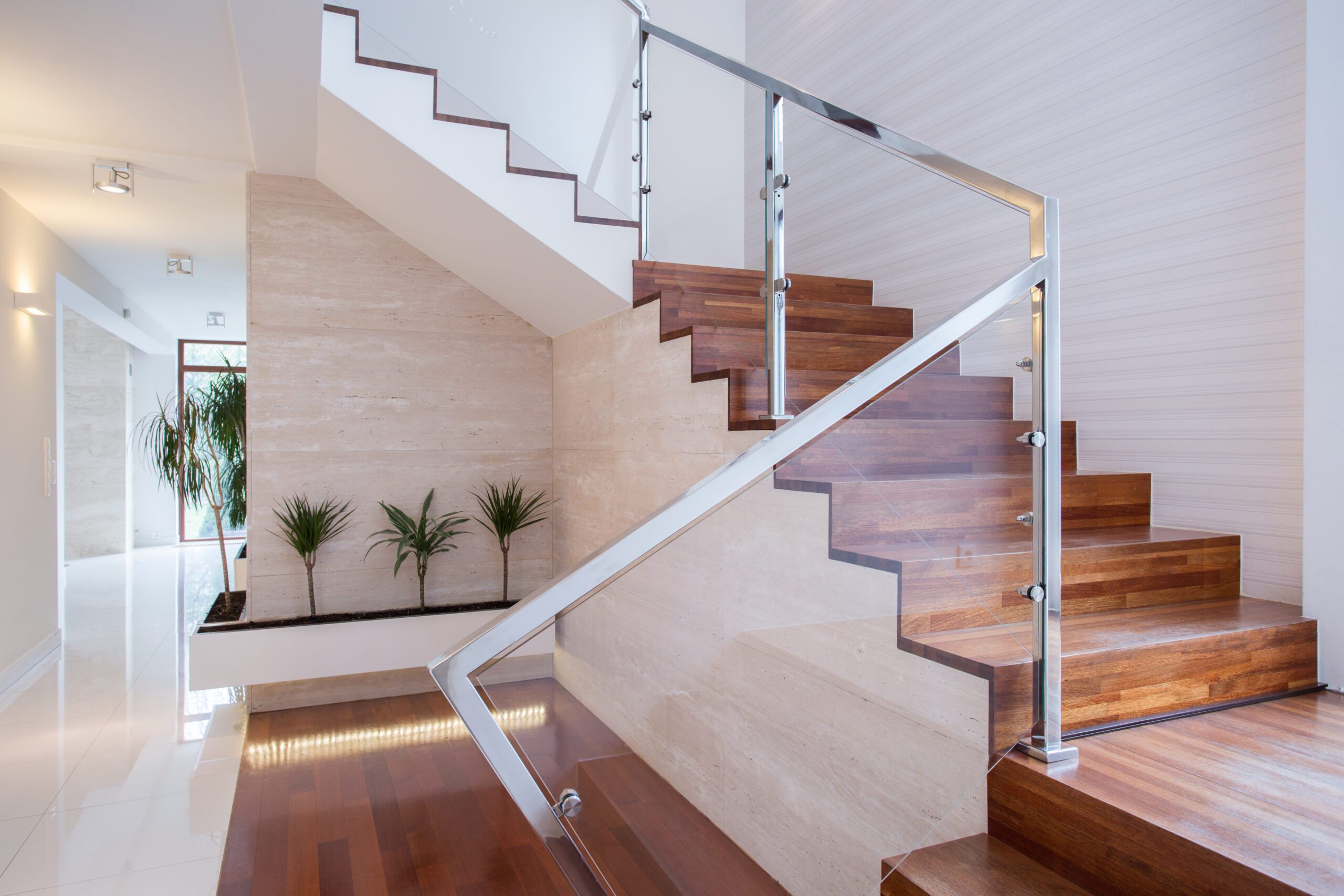 There is a staircase with glass railings